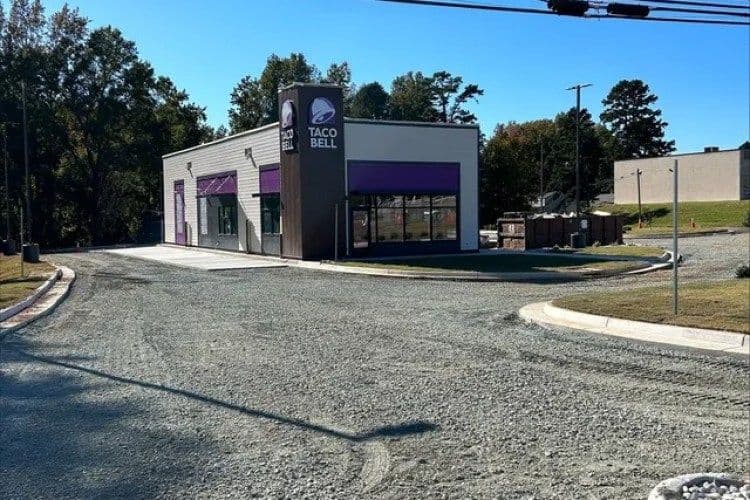 Newly constructed Taco Bell restaurant on gravel lot, featuring modern architecture and signage.