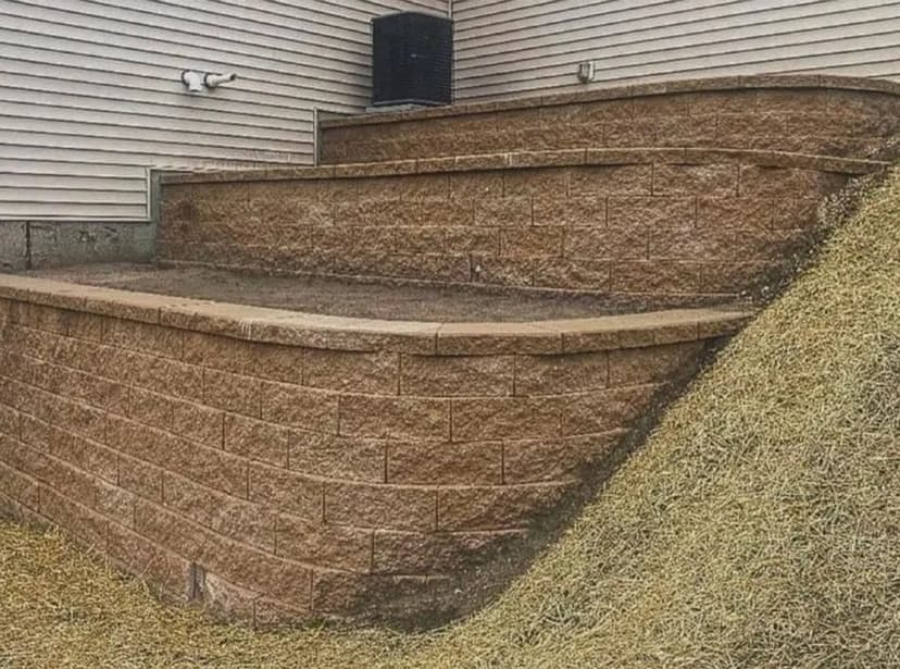 Textured retaining wall and sloped landscaping in a backyard setting.